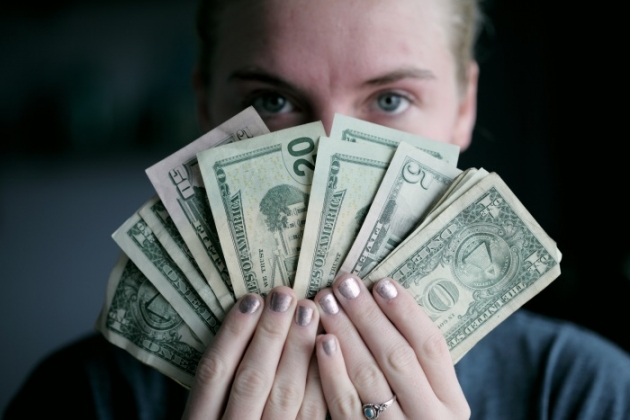 how-to-make-money-as-a-travel-bloger-woman-holding-money